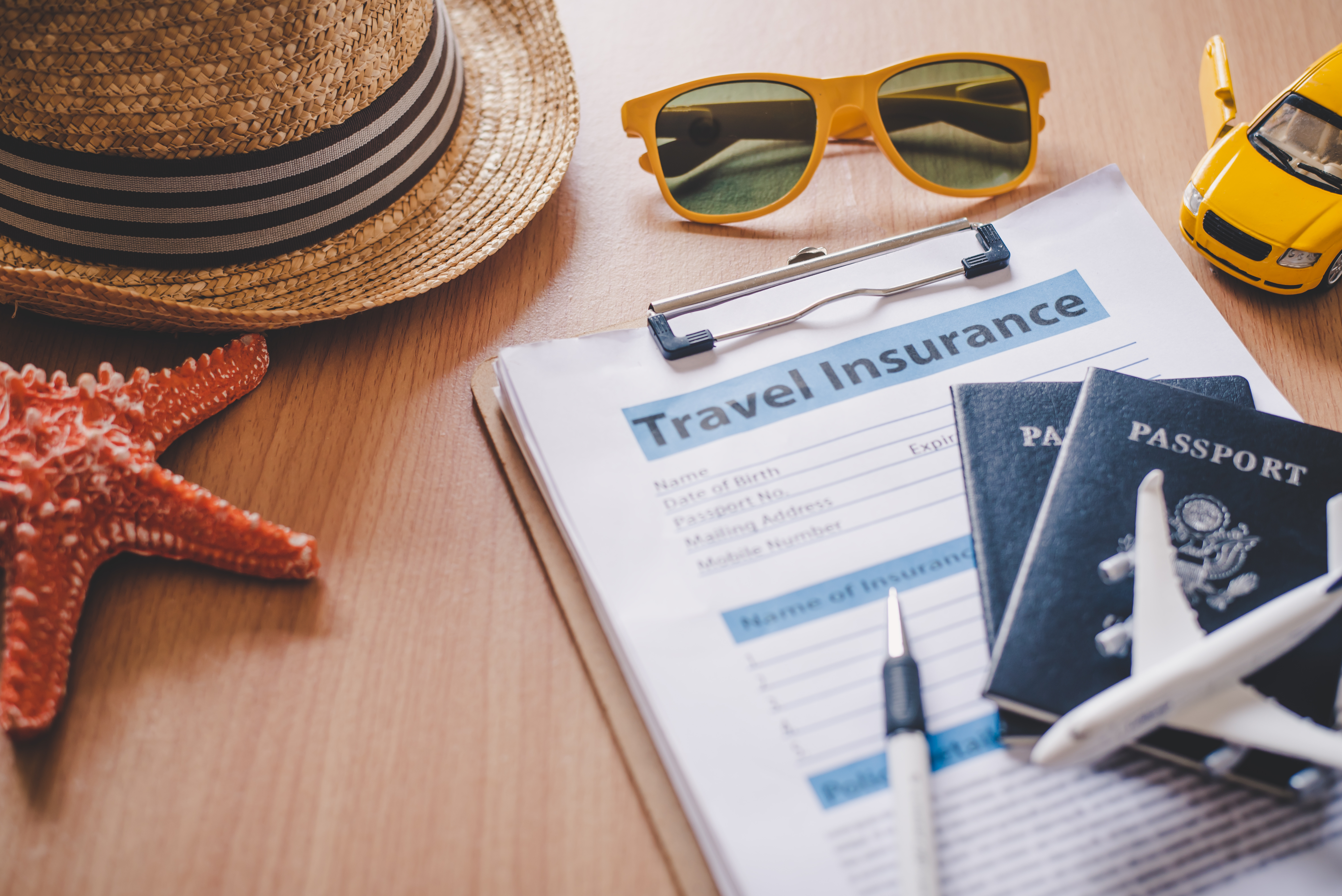 Travel insurance form with passport and various vacation items