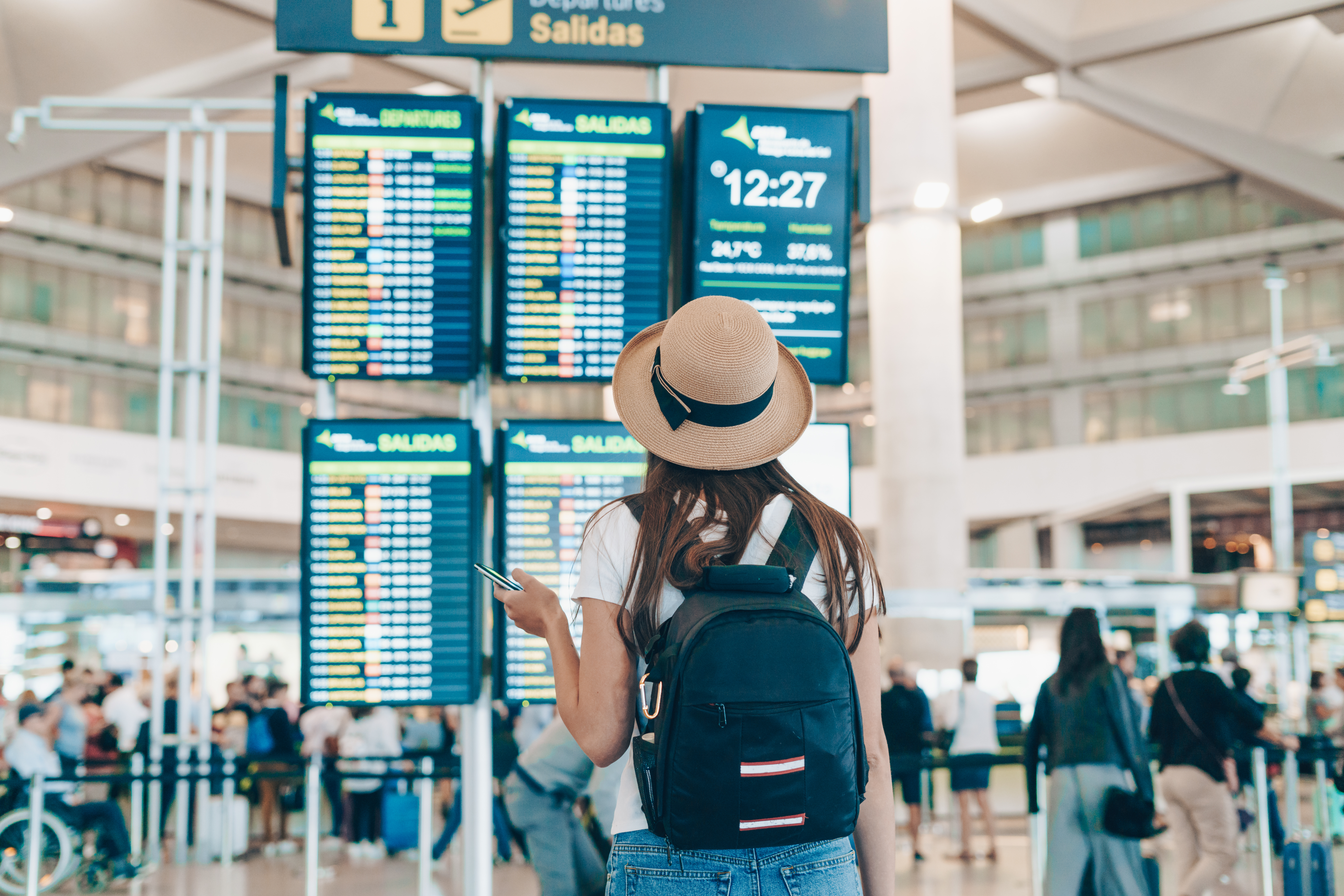 Woman at airport looking at flight schedule boards