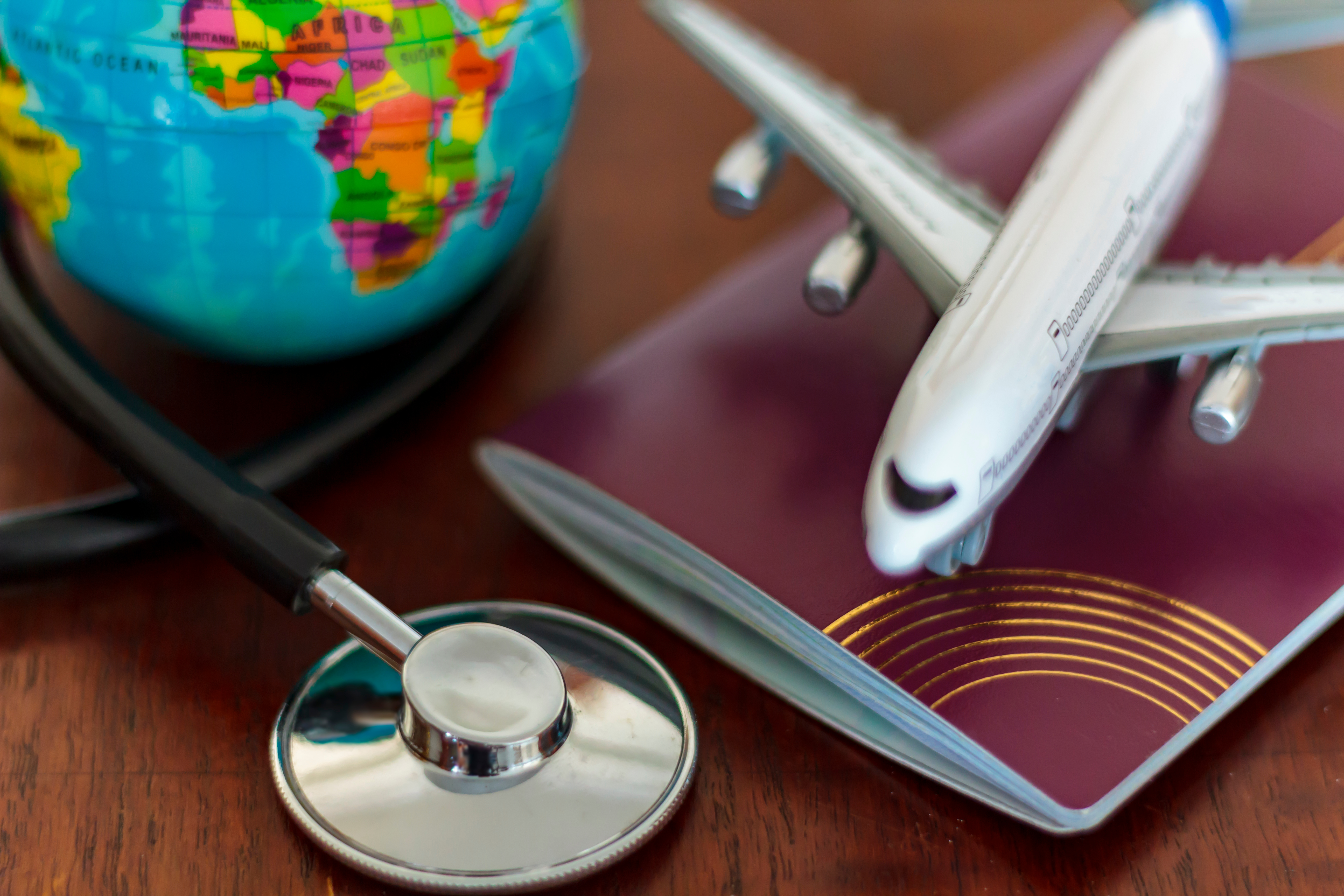 Toy plane, globe, passport and stethoscope