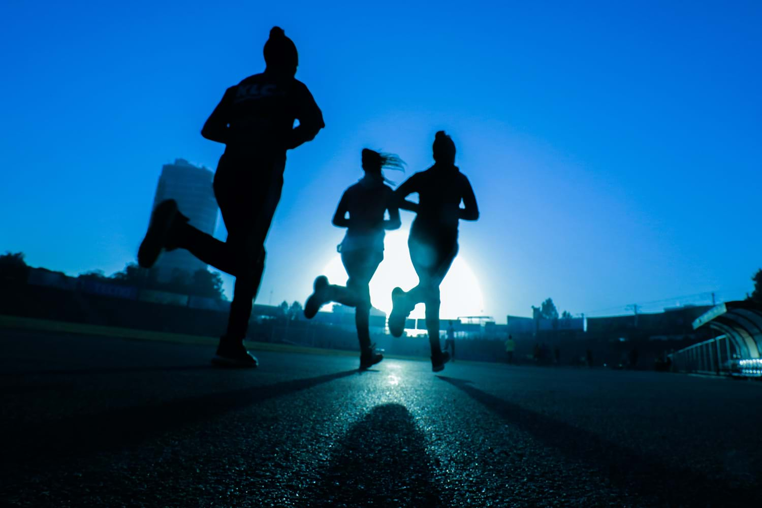 Three women running at sunrise