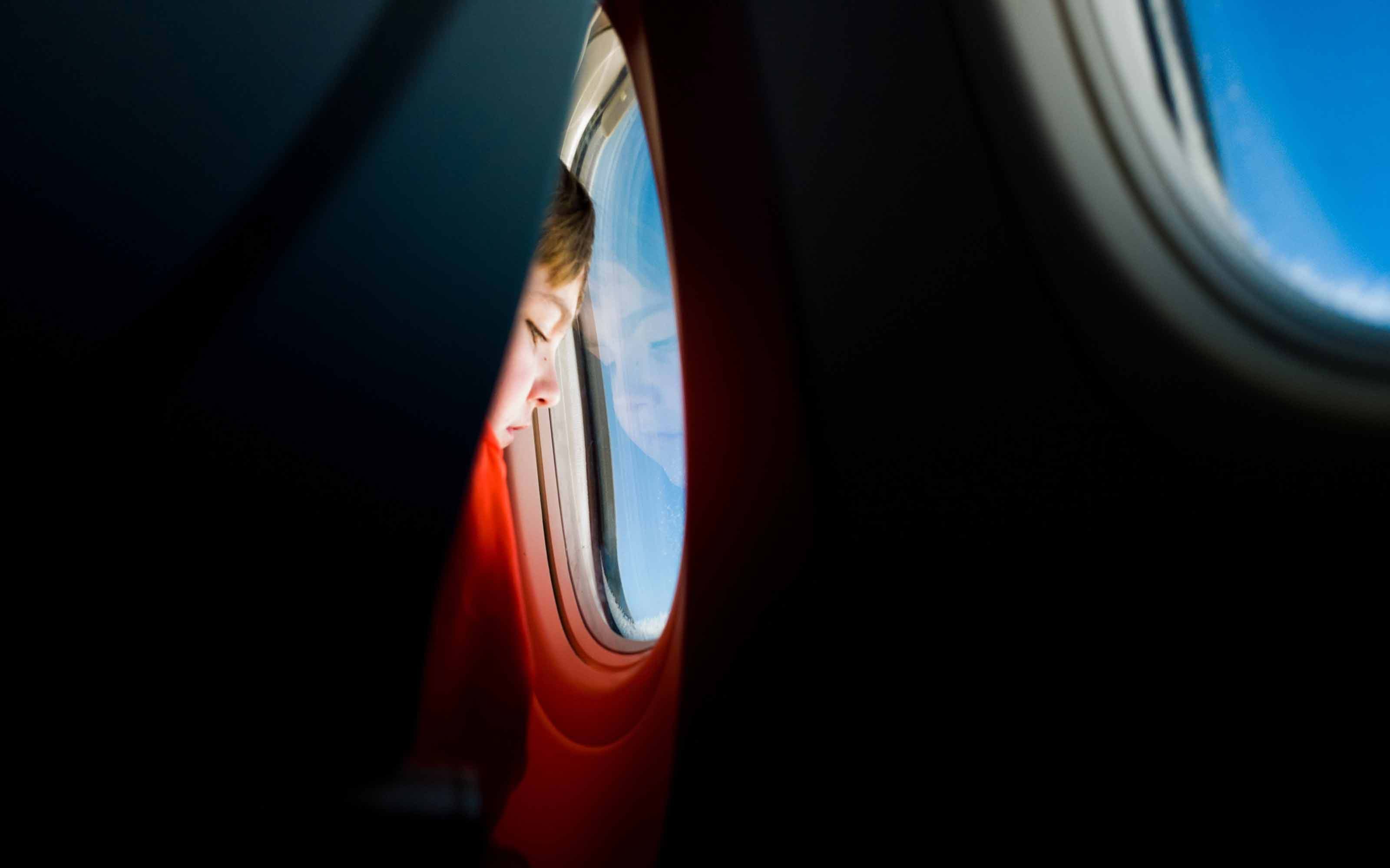 Child looking out airplane window