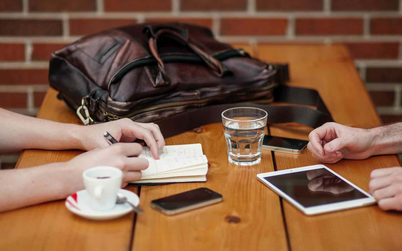 Person writing in book in cafe