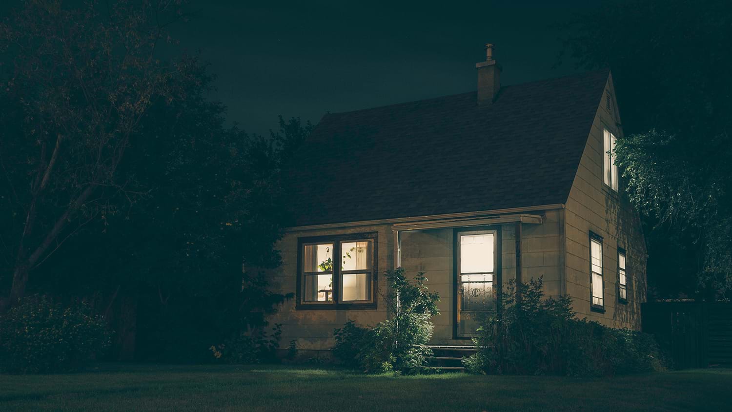 Small house with lit windows at night