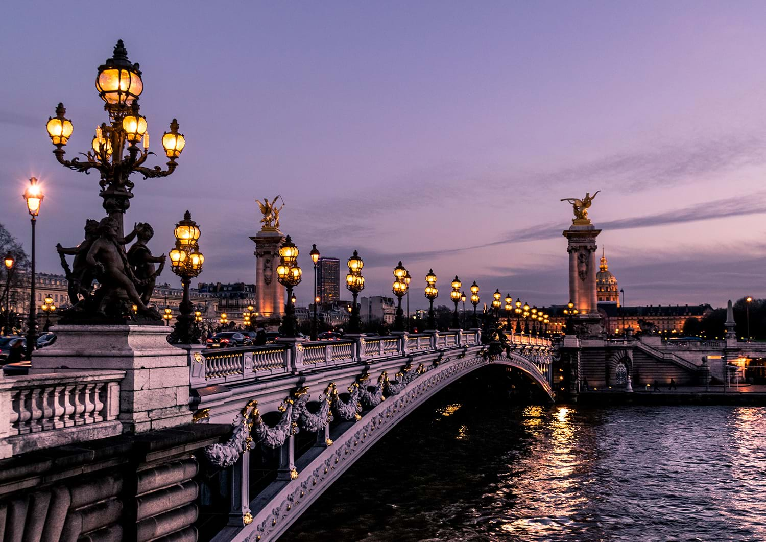 Ornate bridge over river at dusk