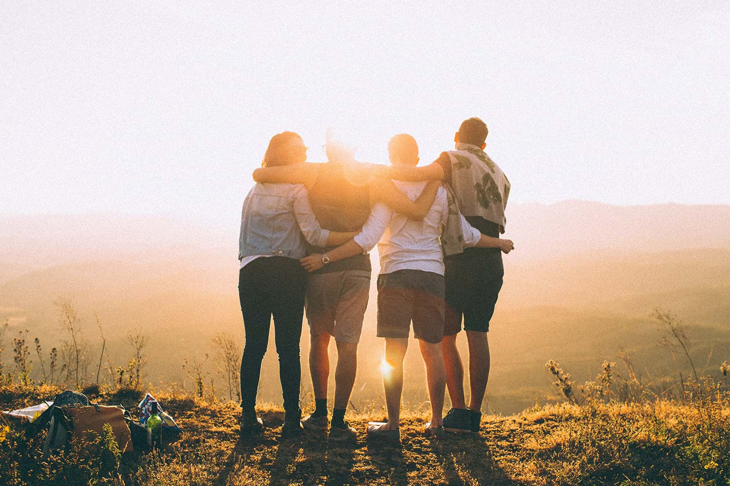 Four friends on a hill at sunset