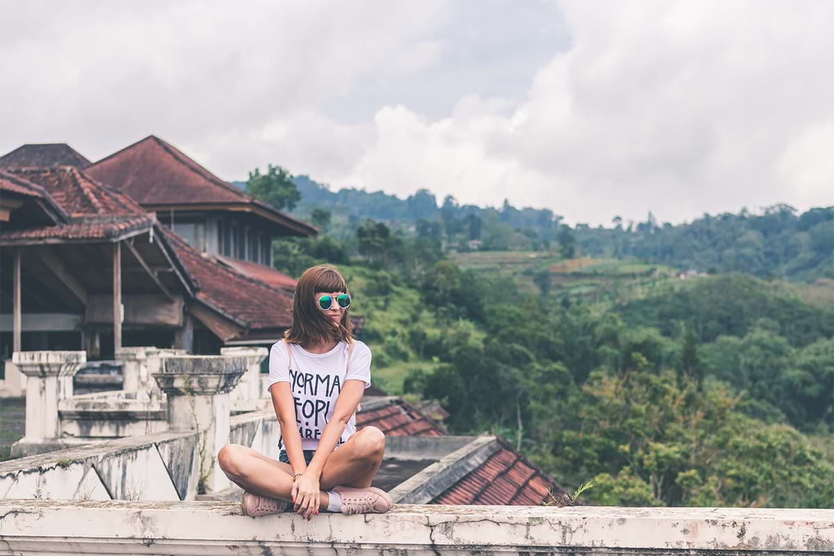 Young woman sitting on wall