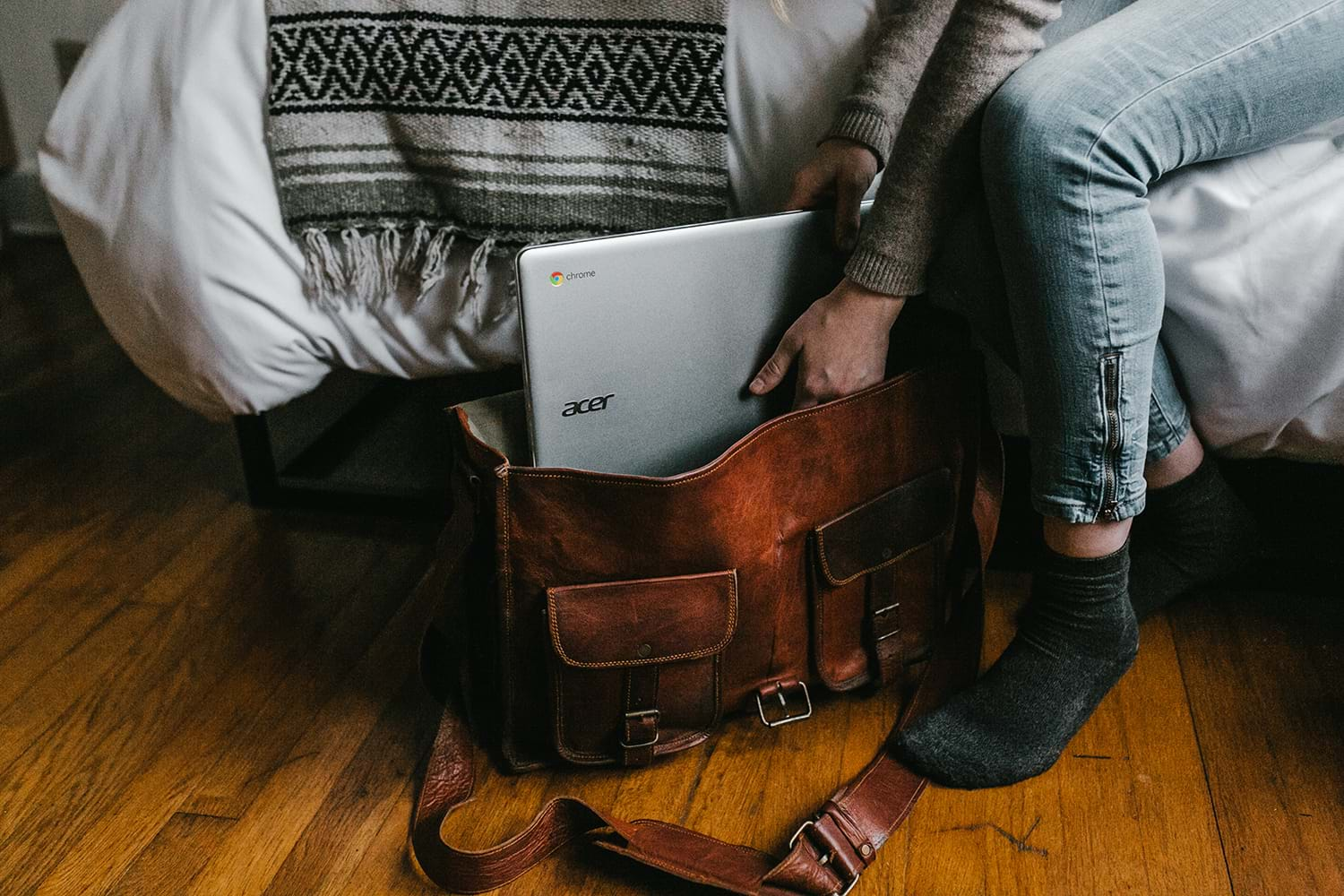 Person packing laptop into bag