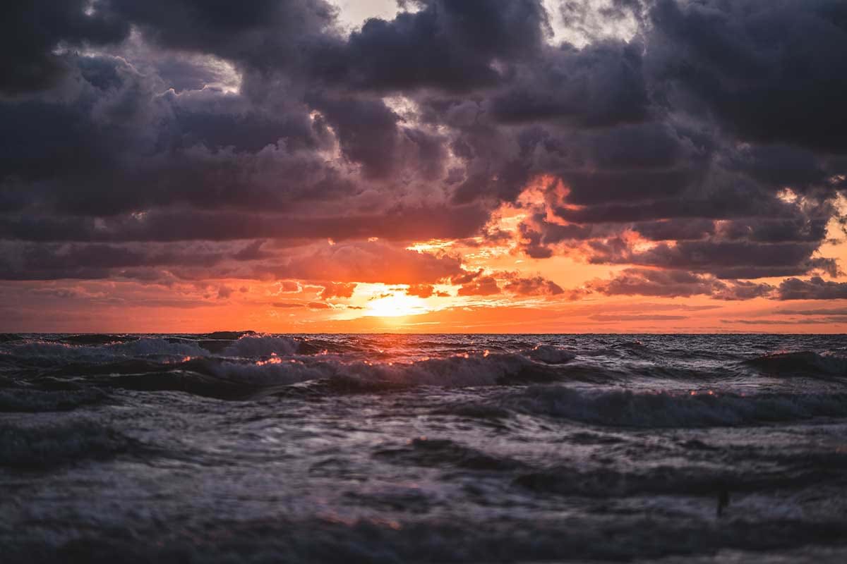 Rough ocean waves and cloudy sky at sunset