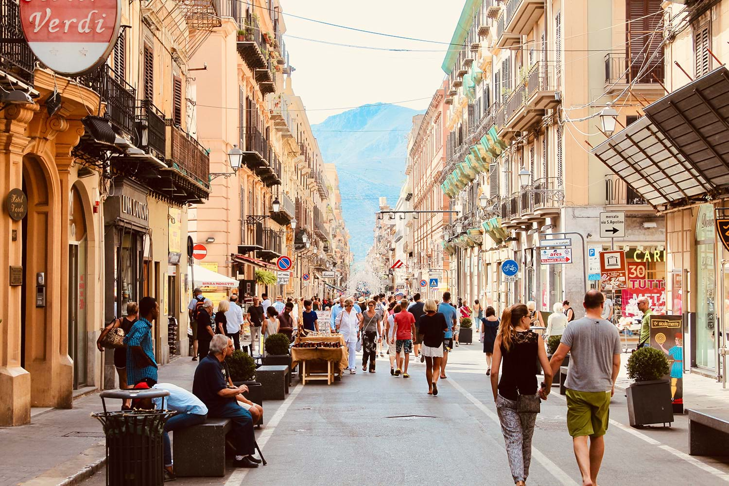 People walking down street with shops 