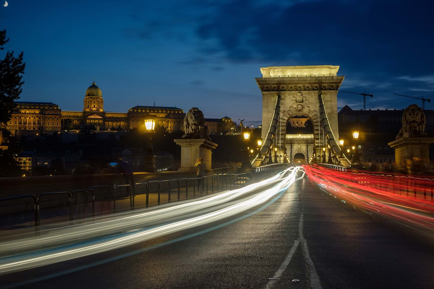 Lights of cars speeding past crossing bridge