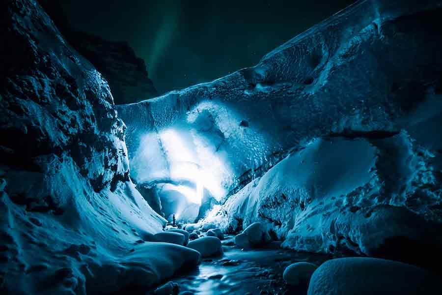 Person with flashlight in Icelandic icy cave