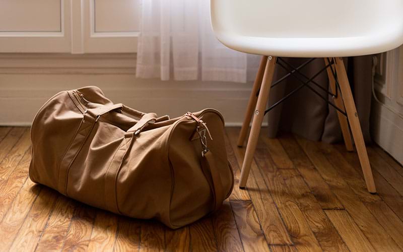 Brown dufflebag sitting on the floor