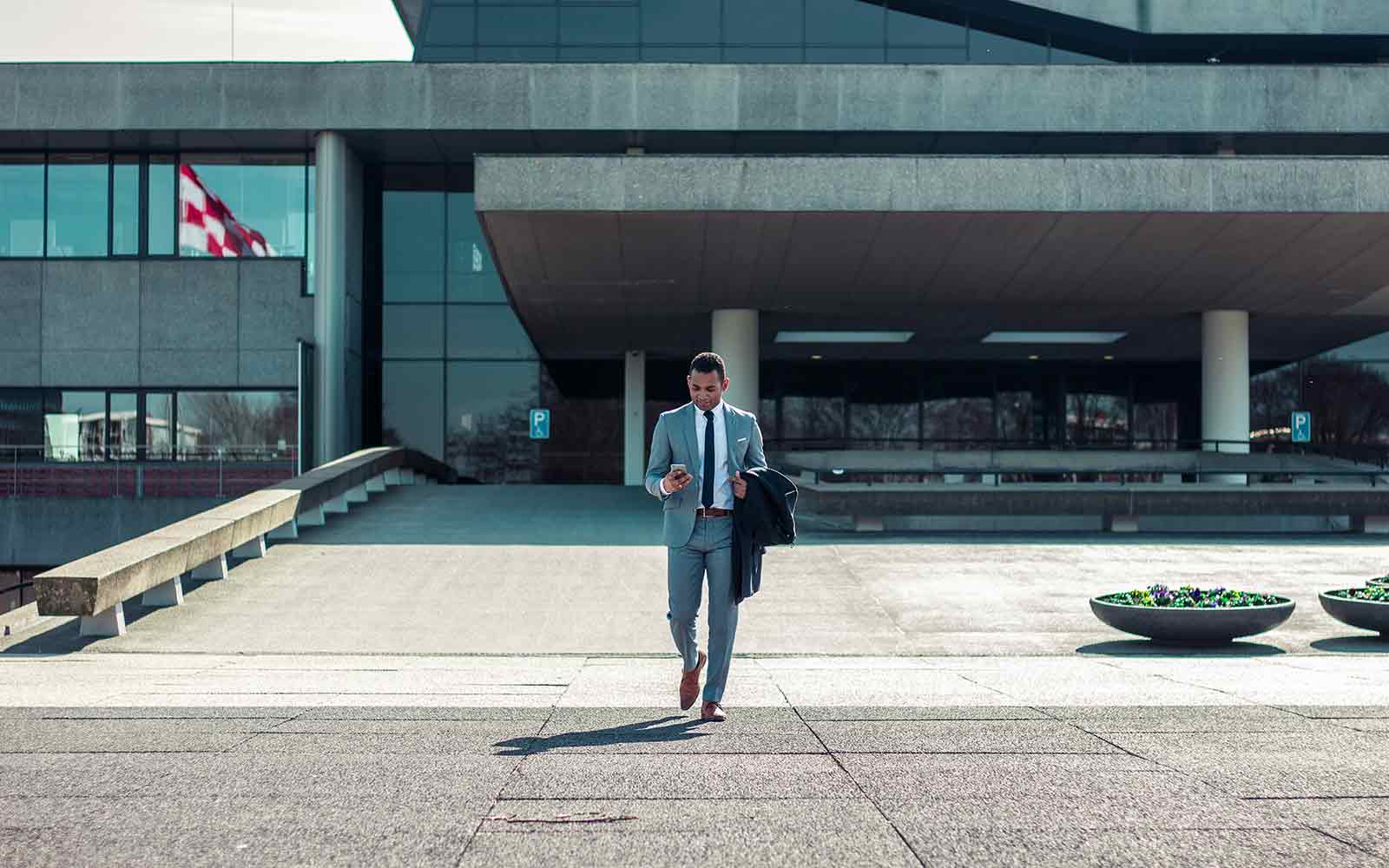 Man in suit walking out of concrete building