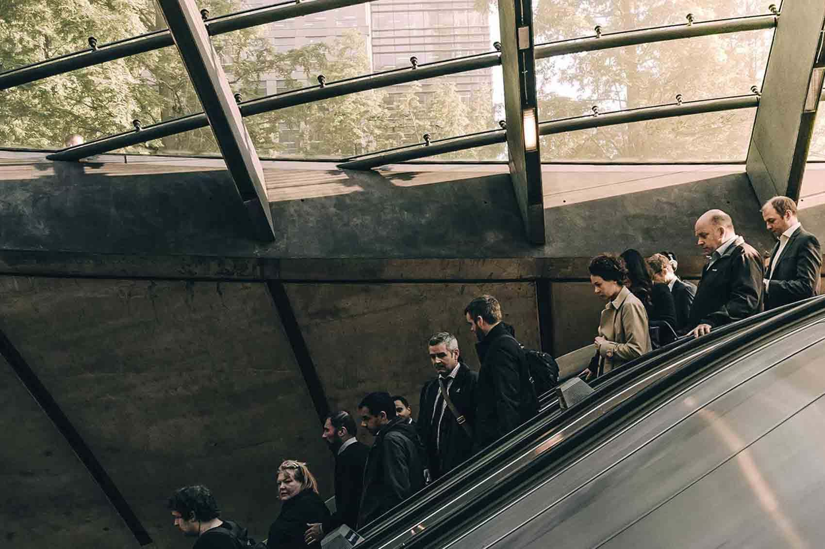 Line of people going down escalator