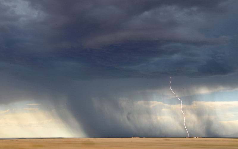 Dark storm clouds and bolt of lightning