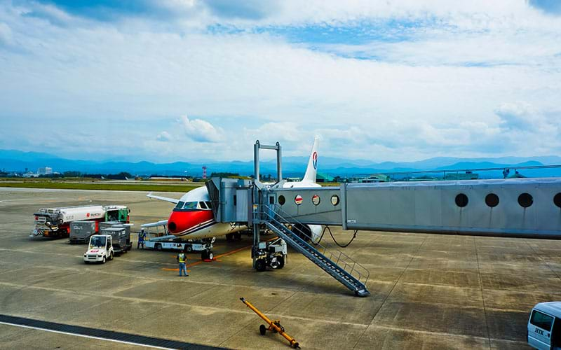 Plane attached to gate bridge on tarmac