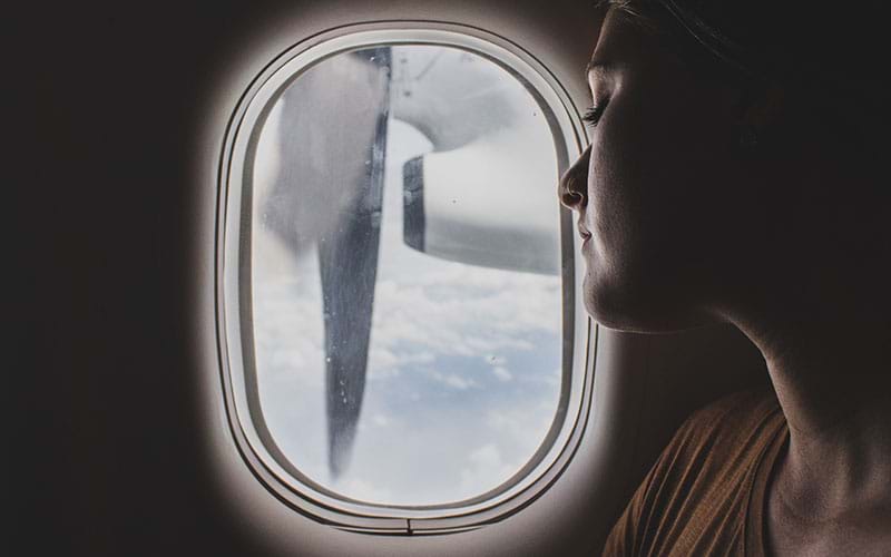 Woman sitting next to plane window