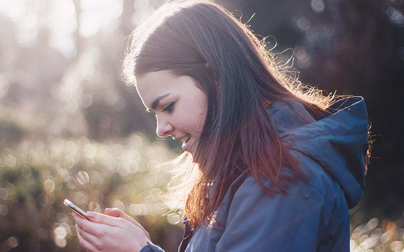 Woman outside looking at phone