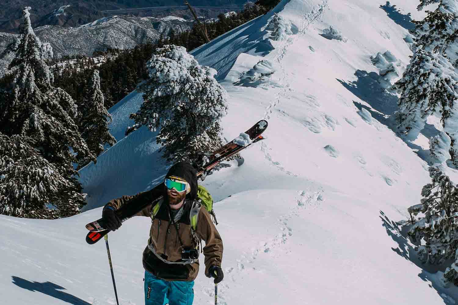 Skier walking back up snow covered hill