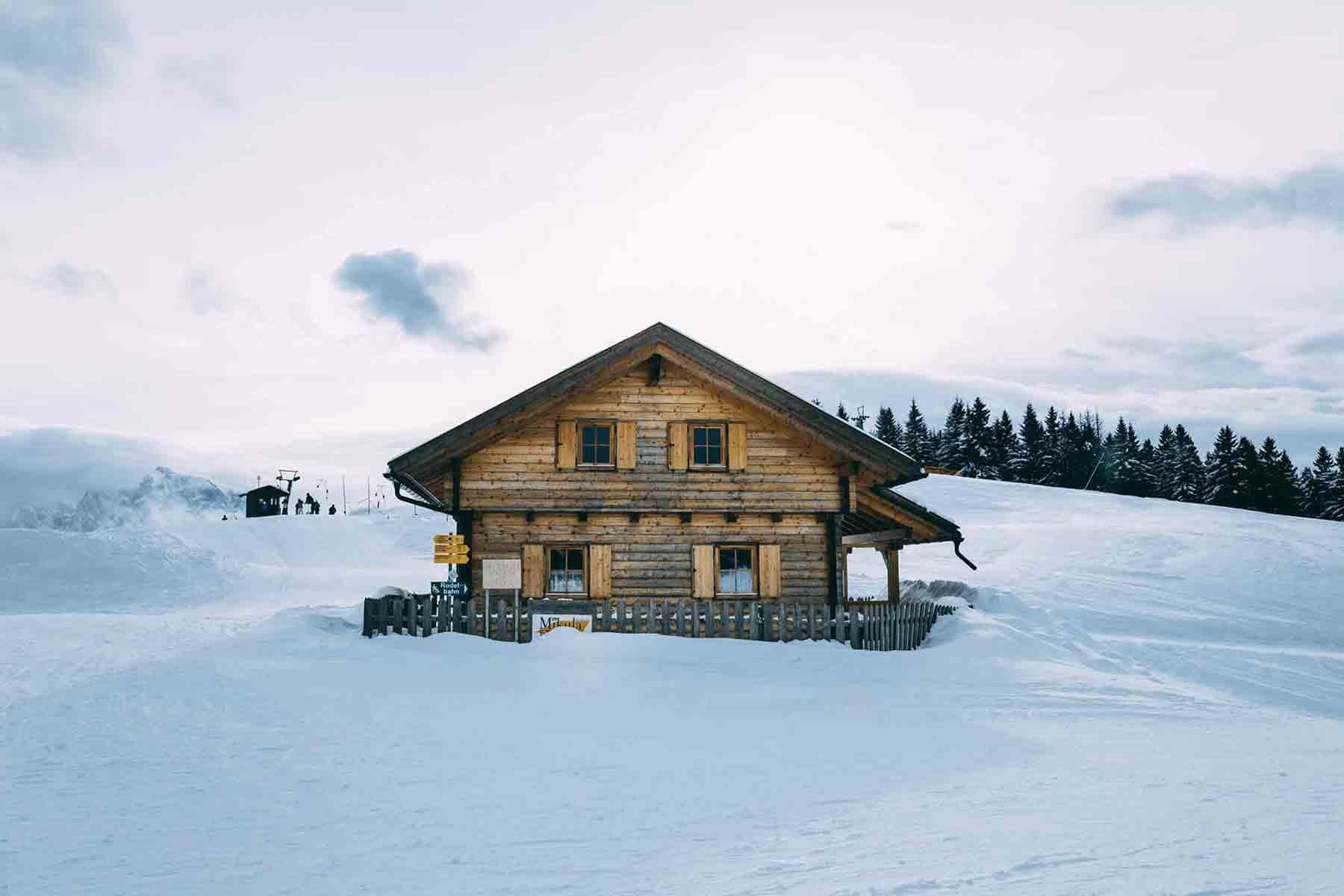 Wood cabin on hill surrounded by snow
