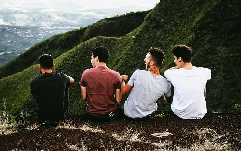 Four friends sitting together in the mountains