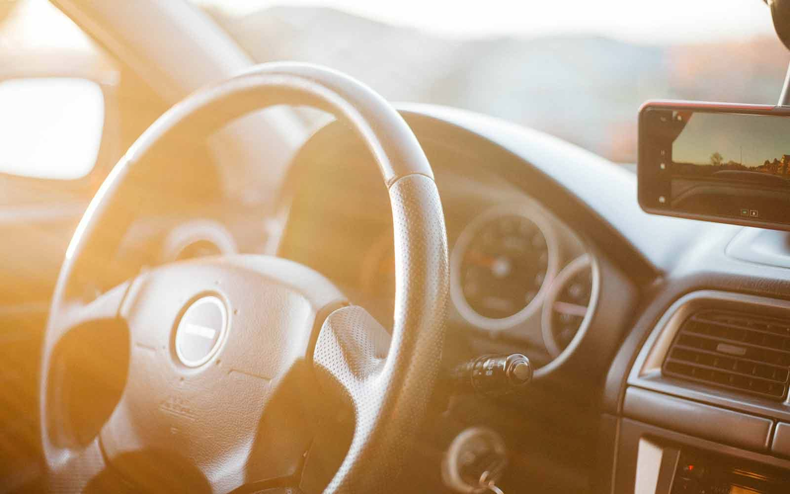 Car steering wheel and phone rigged to windshield 