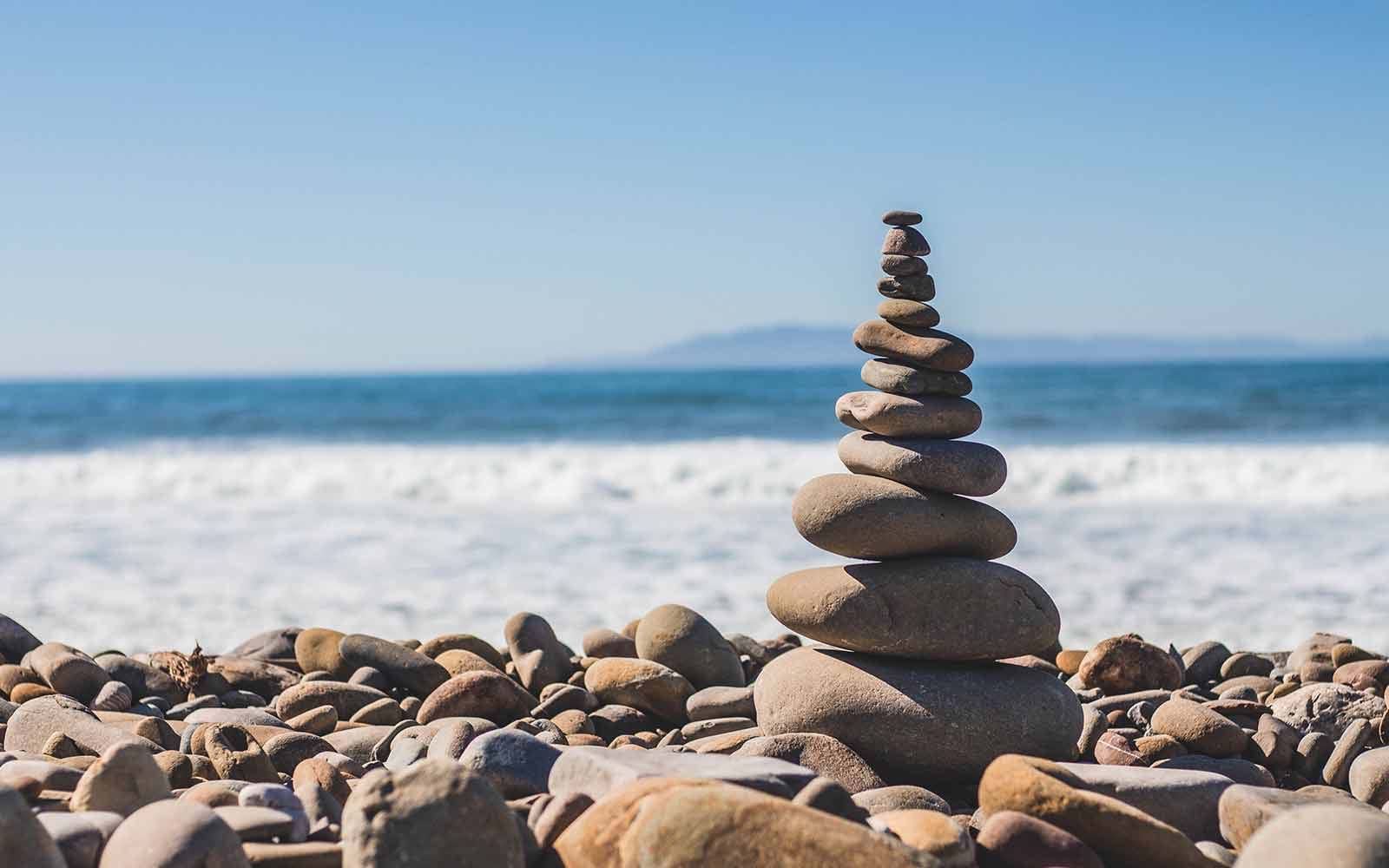 Smooth stones stacked in a pile on shore