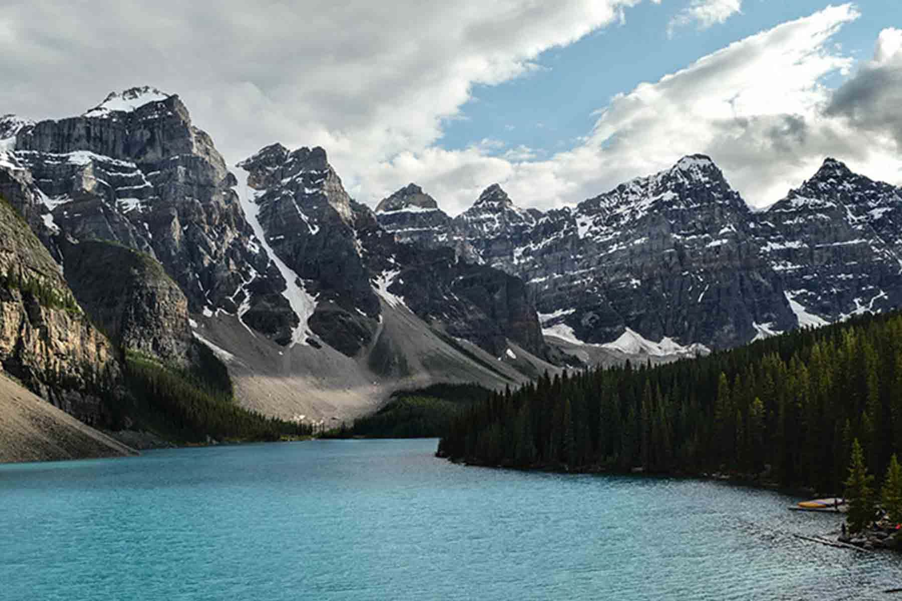 Range of snow covered mountains beside wide river