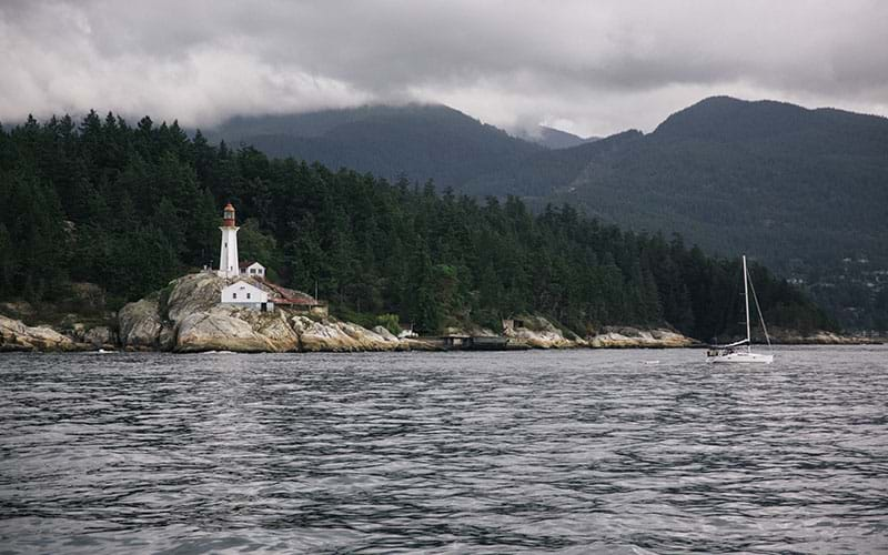 Lighthouse overlooking lake on cloudy day