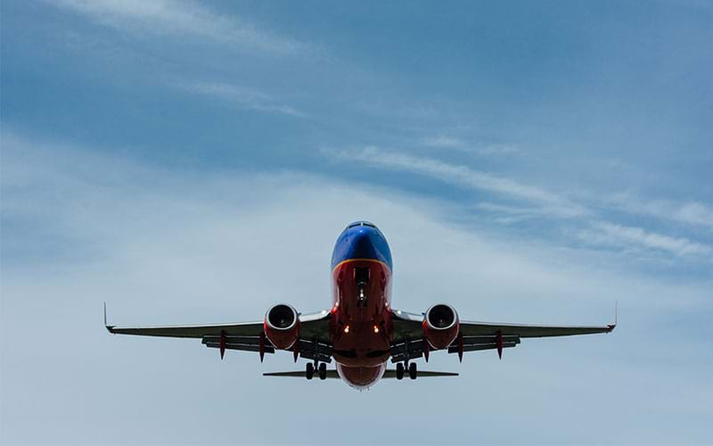 Red and blue plane flying overhead