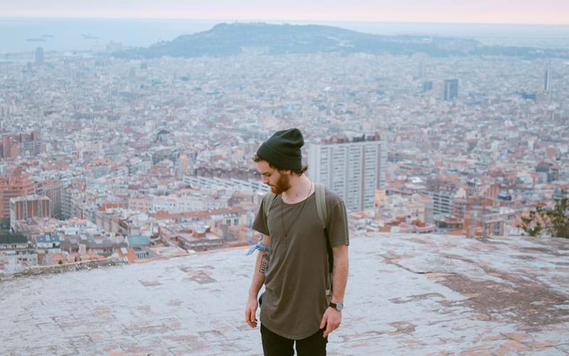 Man on hill overlooking large city