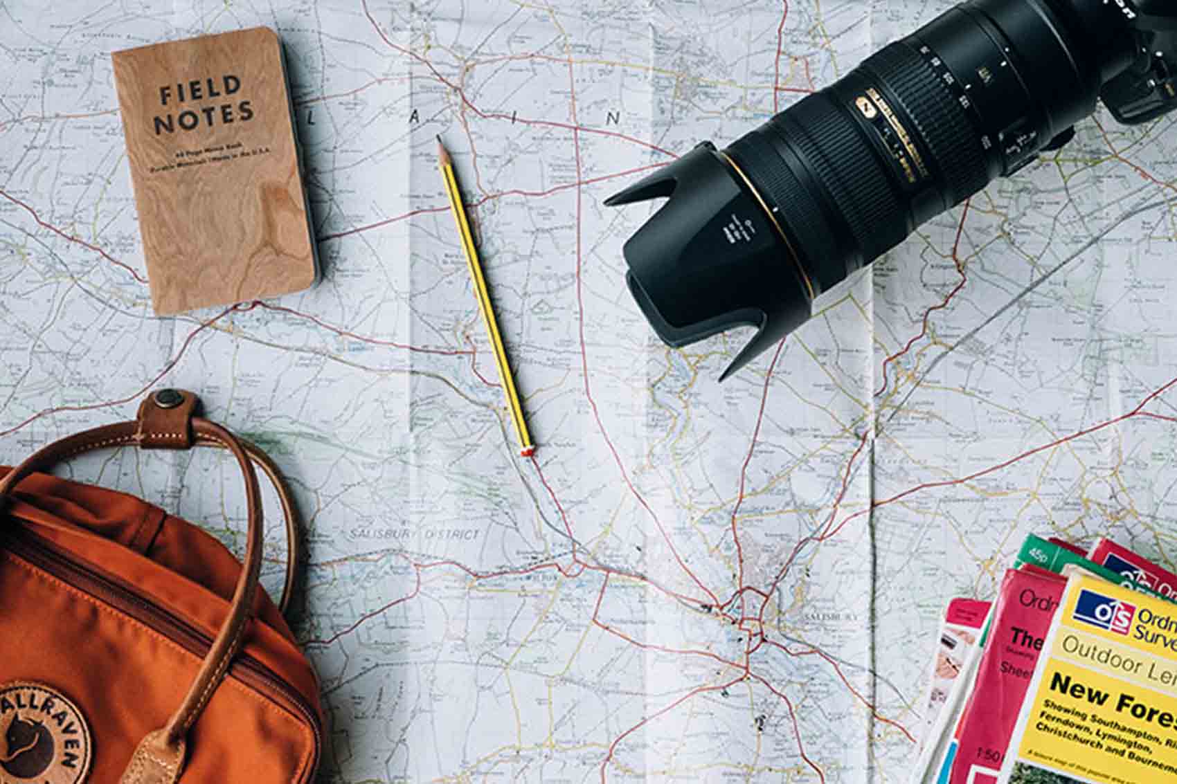 Camera and other travel items on top of map