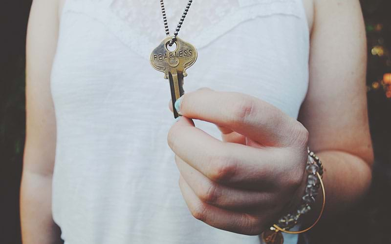 Person holding key that says "fearless"