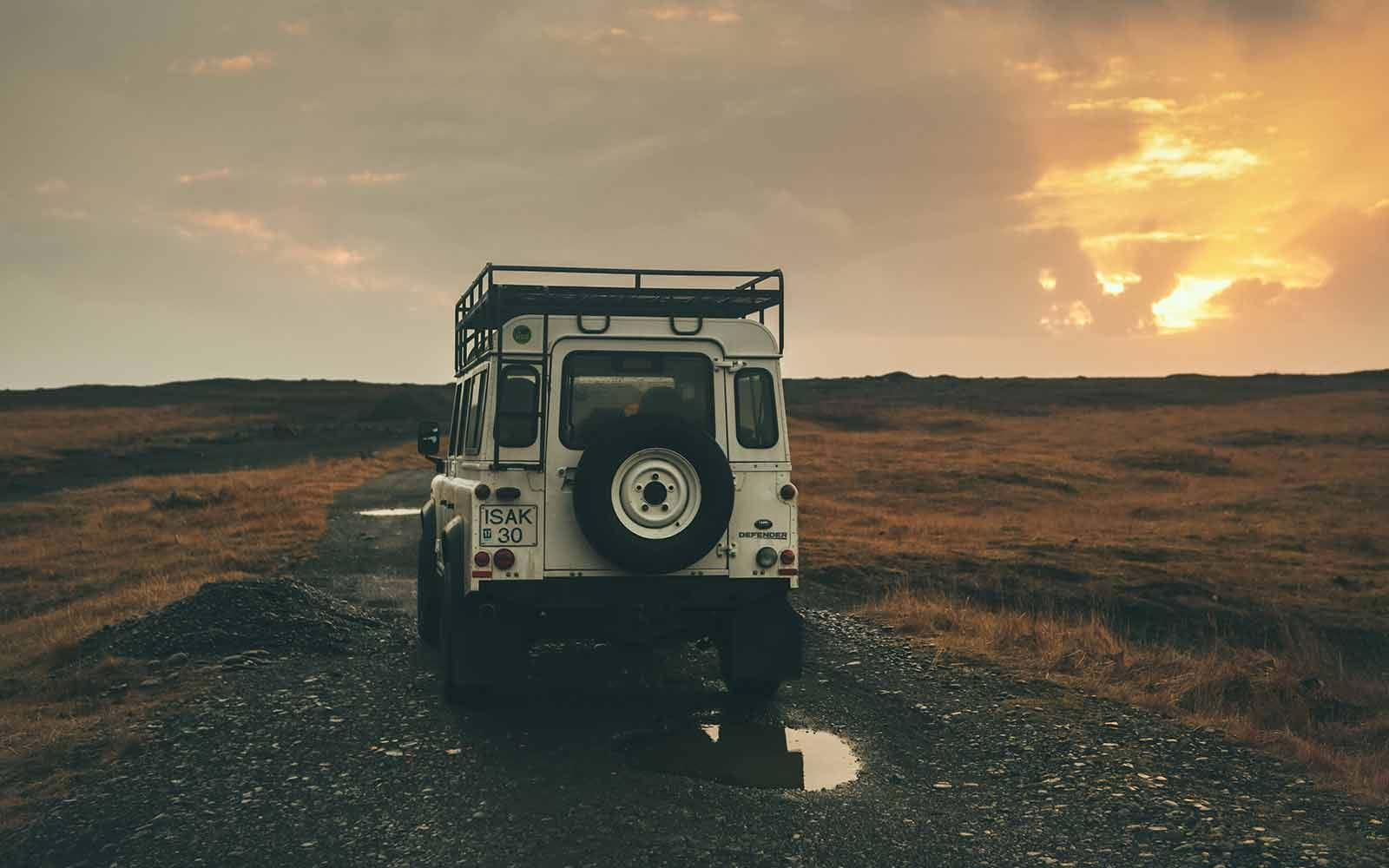 White jeep driving on rough gravel road