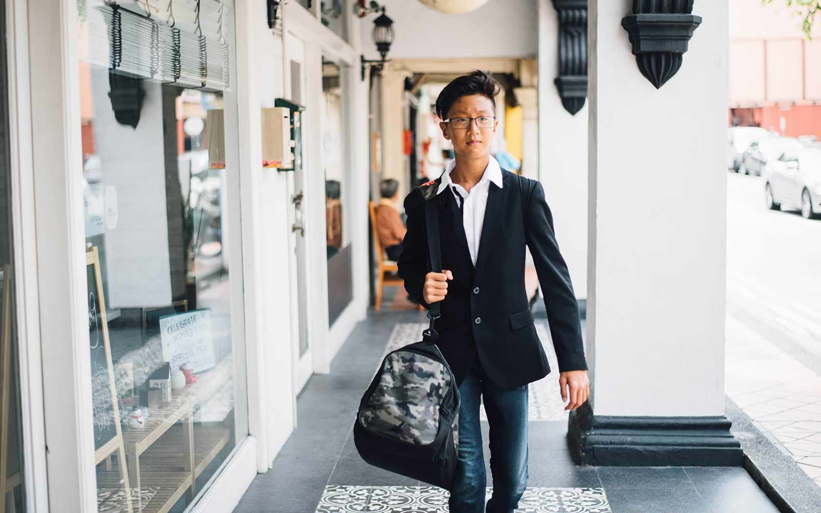 Young man walking and carrying dufflebag