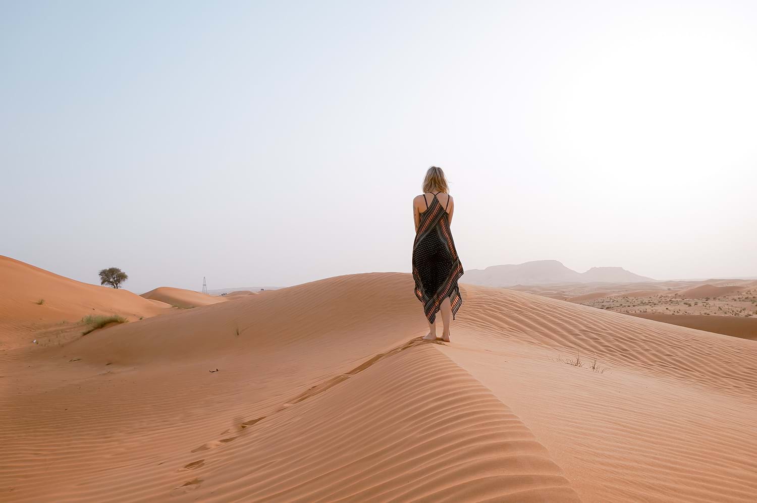 Woman walking on sand dune in desert
