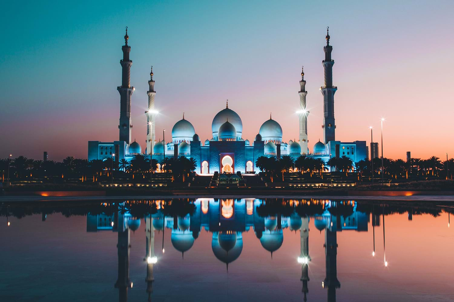 Domed building reflected in small lake at sunset