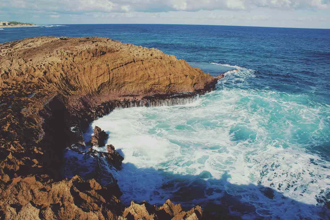 Ocean waves crashing into crevice in rocky shore