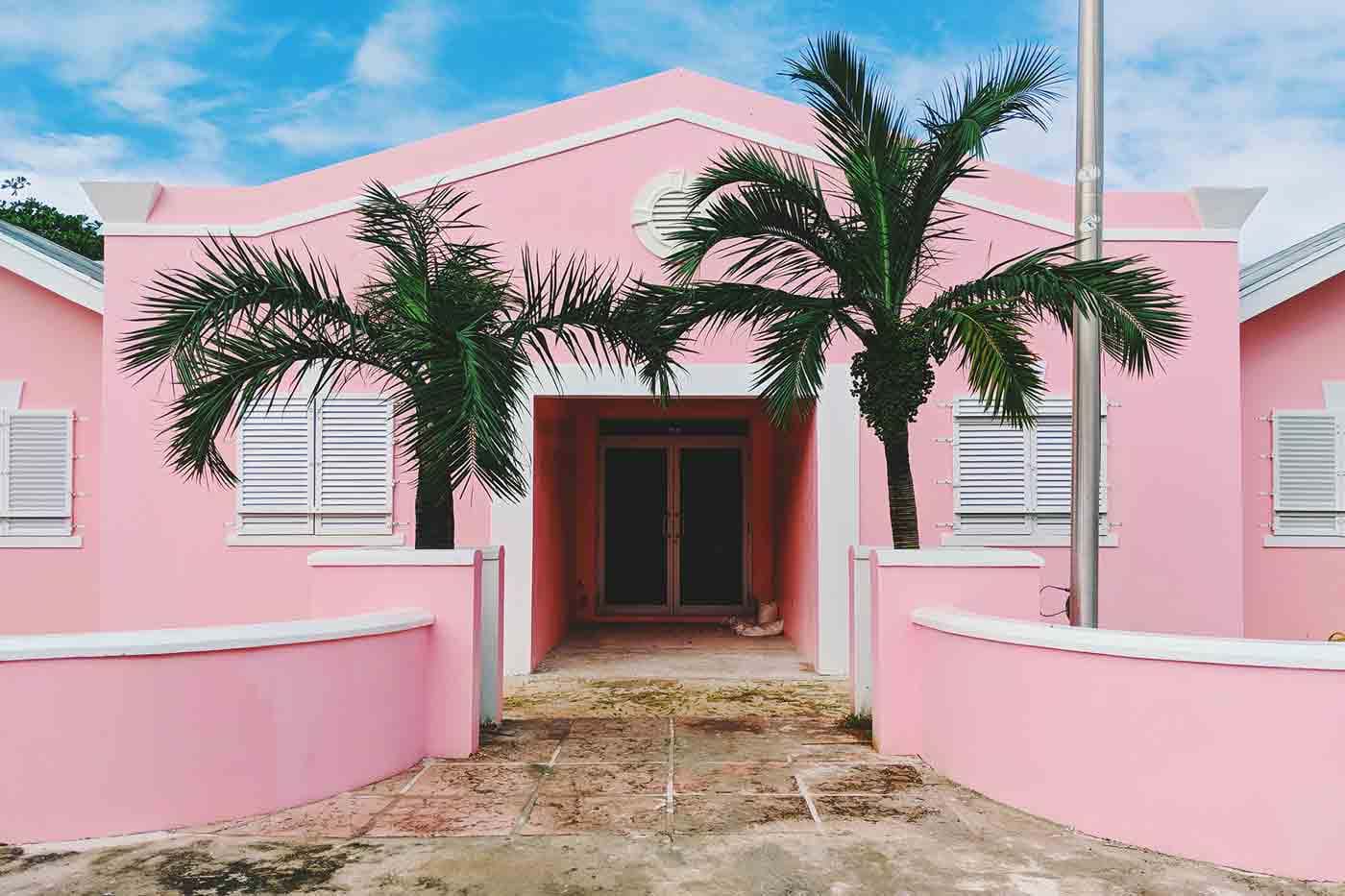 Front of pink house with palm trees