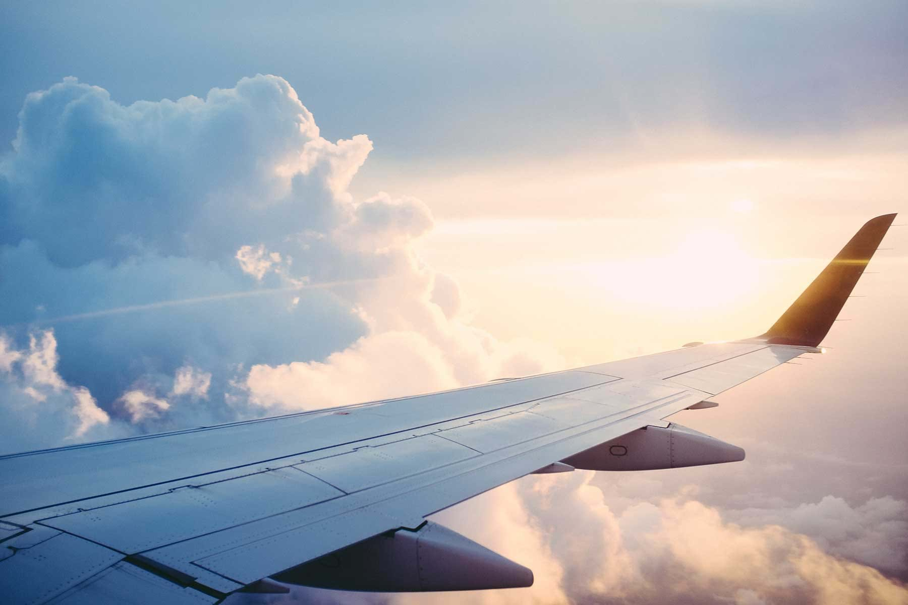 View of plane wing over clouds