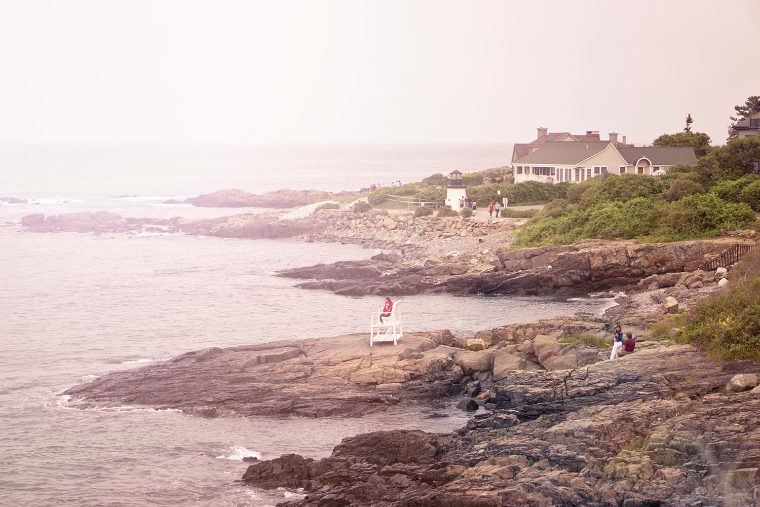 People sitting on rocks on shoreline