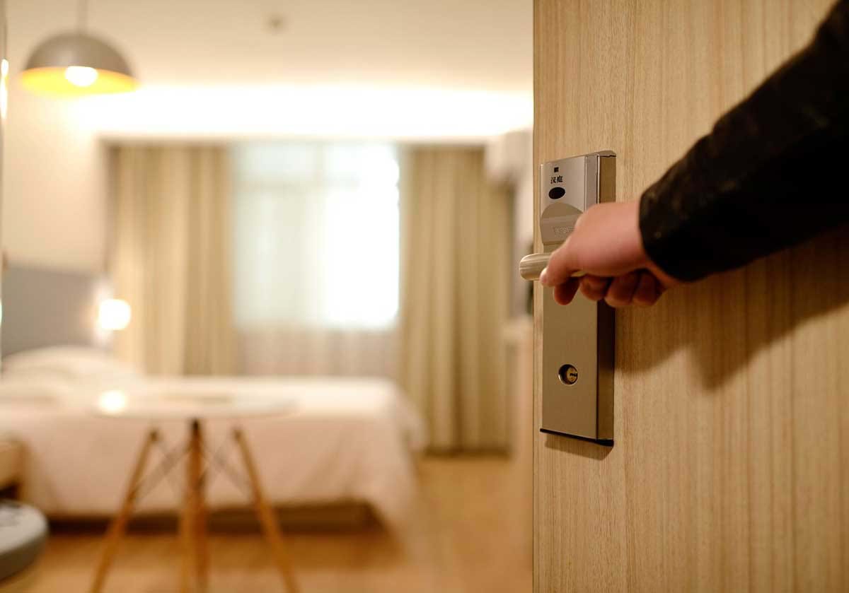 Hand opening door into hotel room