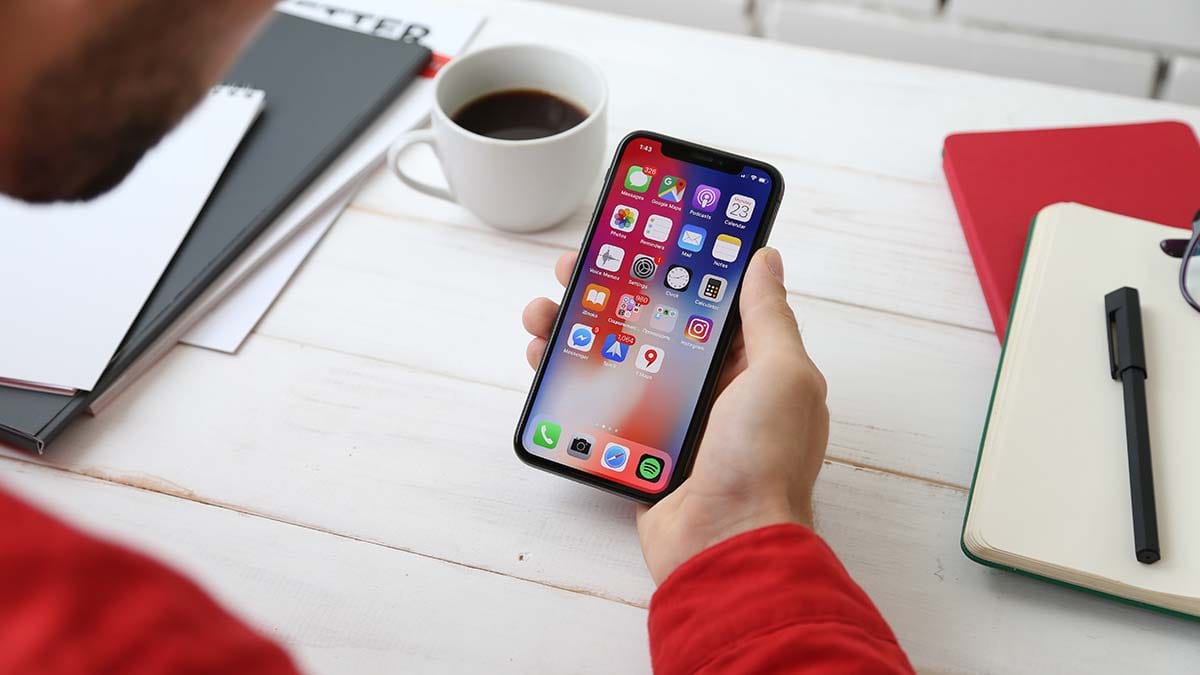 Person sitting at desk looking at smartphone