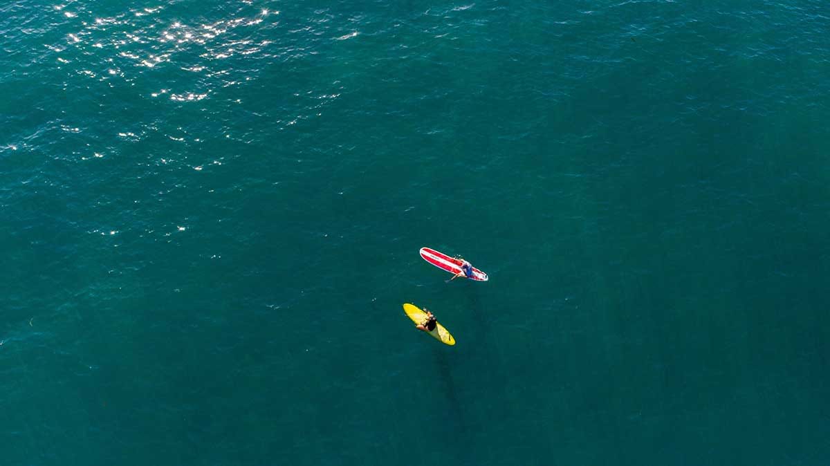 Two people floating on surf boards in water