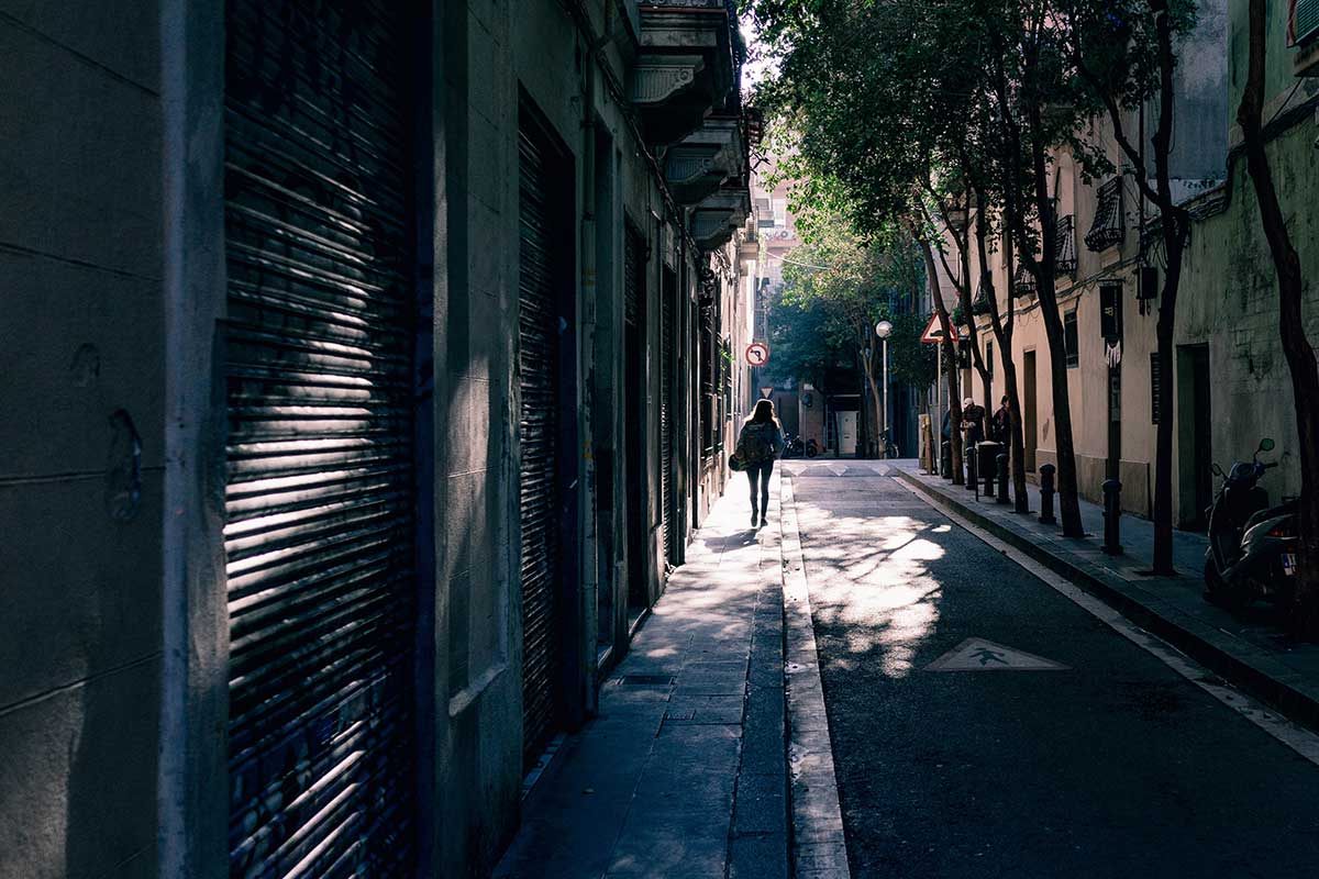 Woman walking down dark city alley