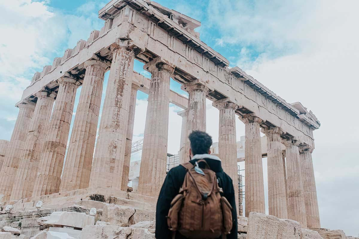 Tourist looks up at anchient Greek ruins