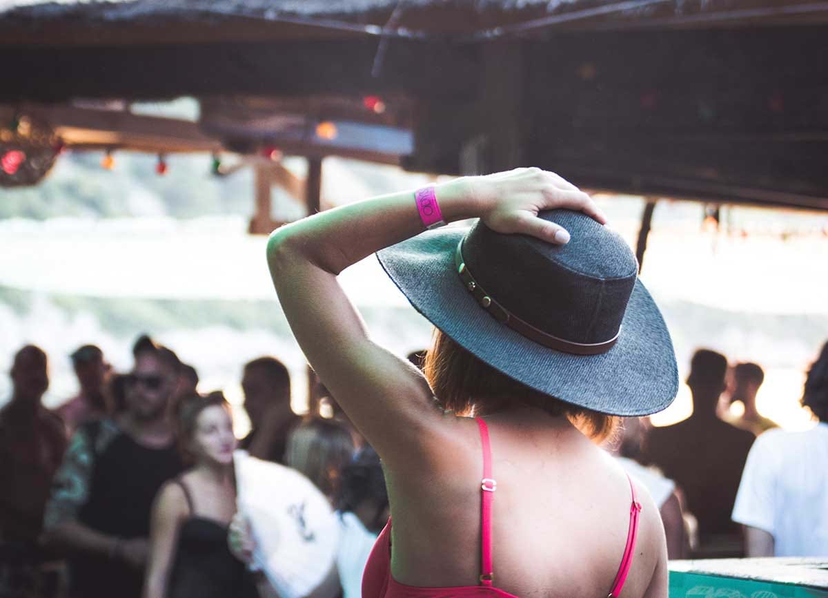 Woman with hat wearing pink wristband