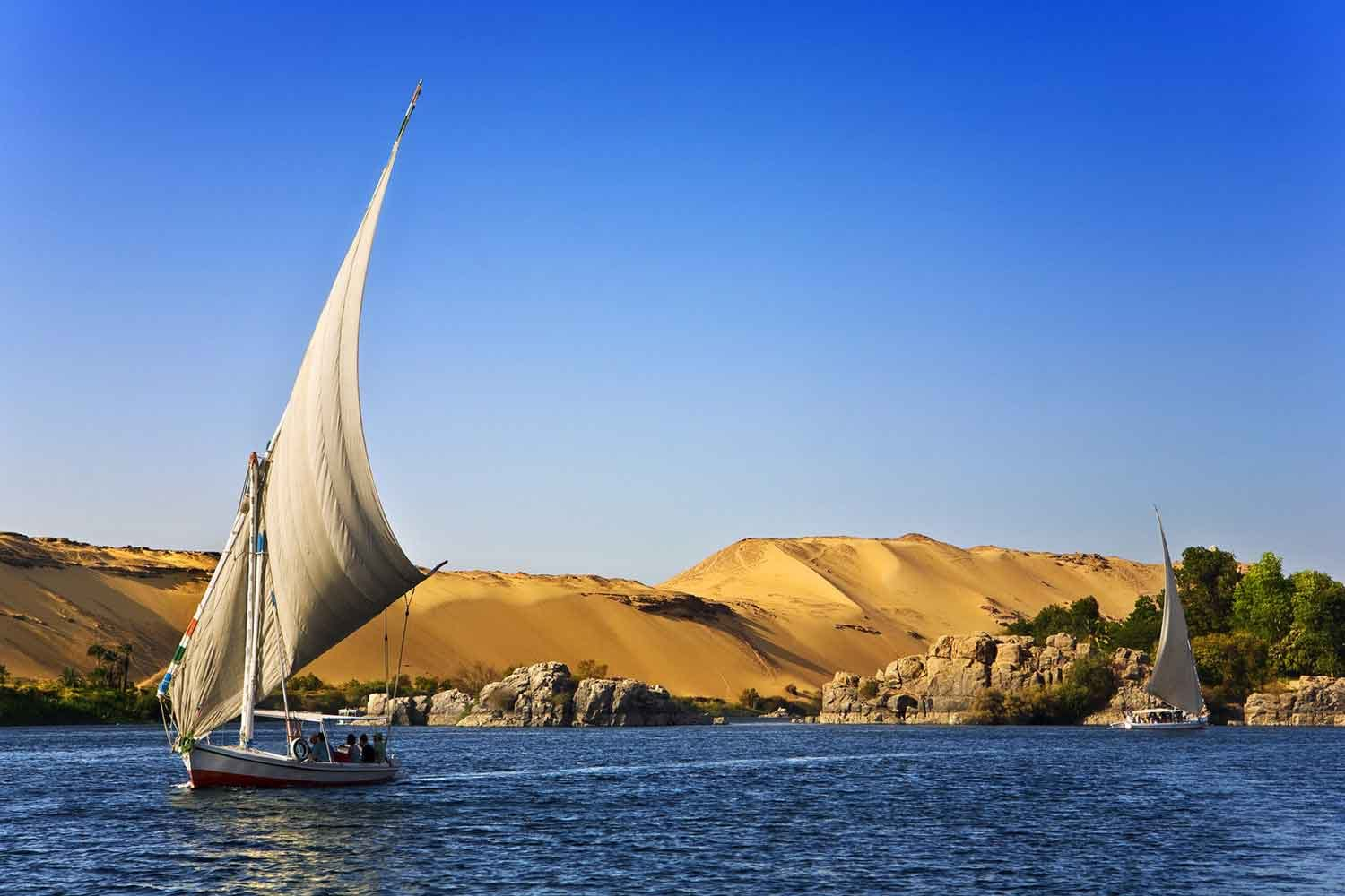 Sailboats cruise down Nile river