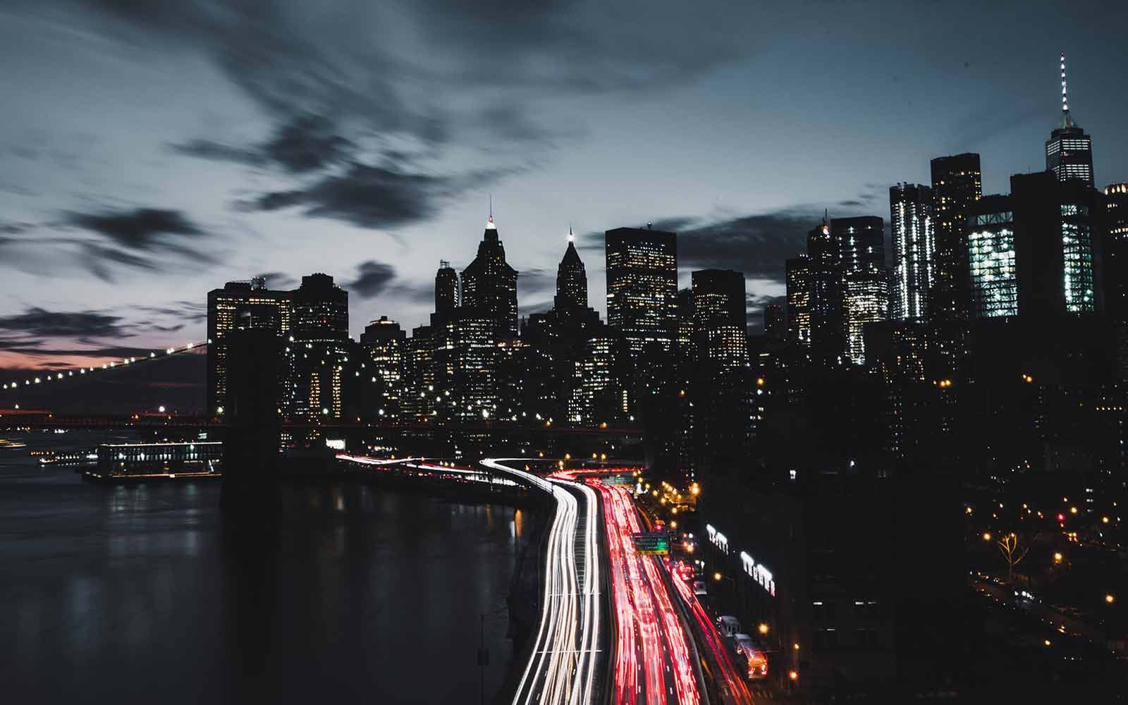 Dark city street illuminated by lights of cars