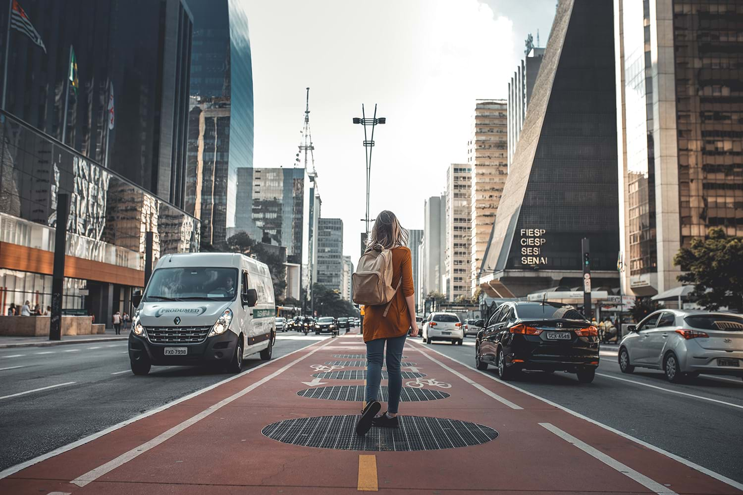 Woman walking in bike lane on busy city street